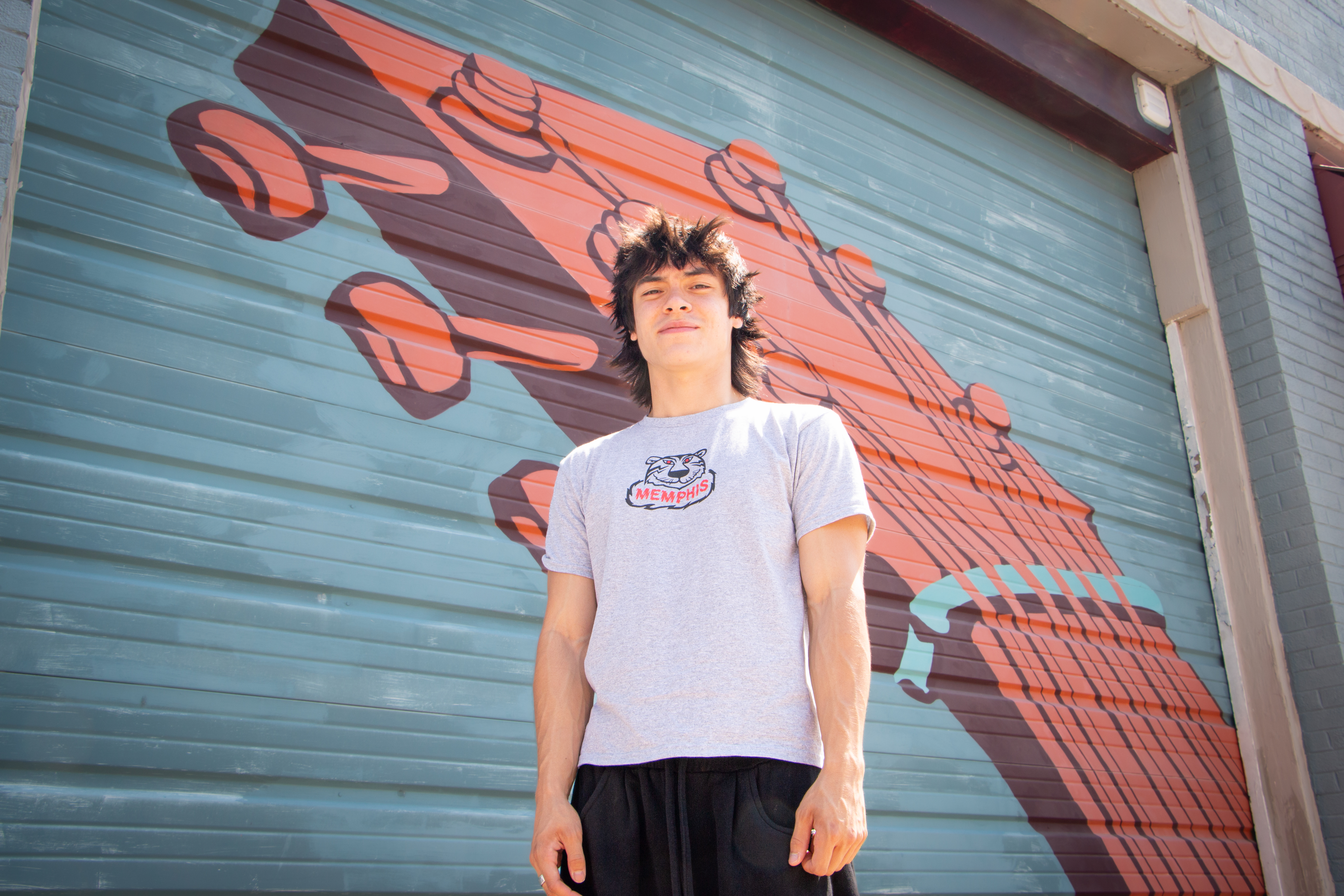 Memphis musician, Aidan Osias, in front of a guitar mural