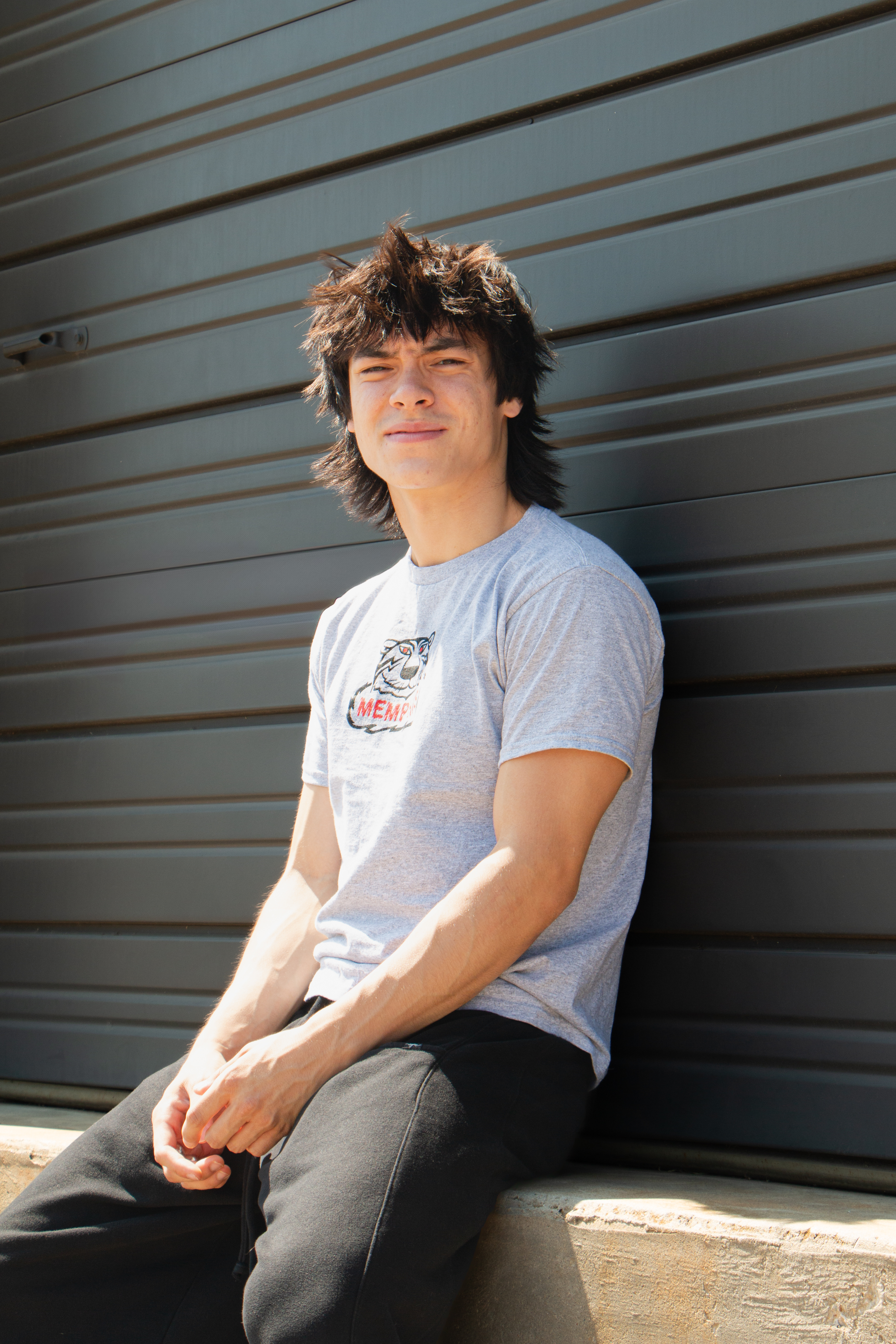 Memphis musician, Aidan Osias, sitting on a ledge